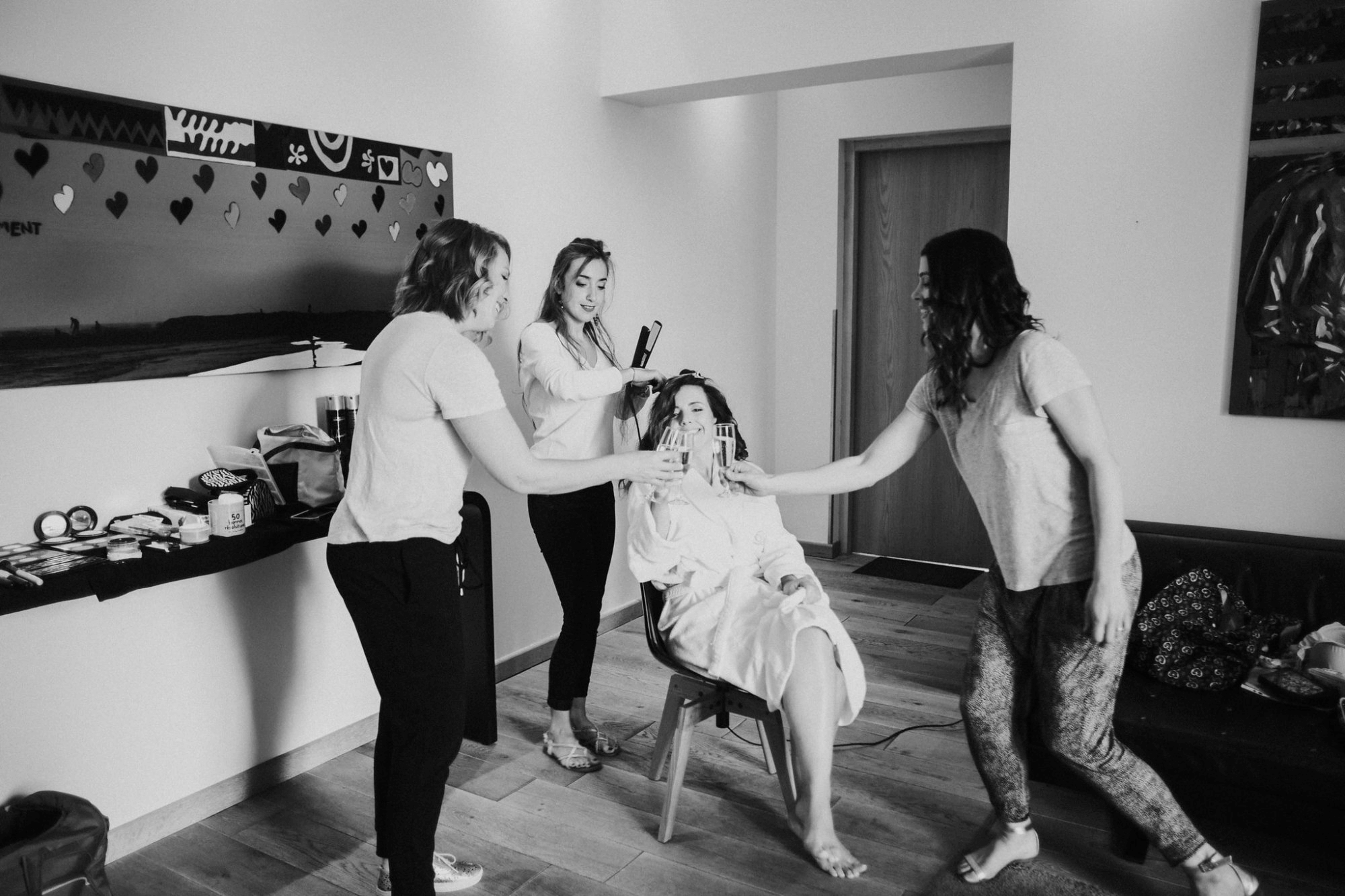 Mariée qui se fait coiffer par Anais Faure en buvant du champagne avec ses demoiselles d'honneur